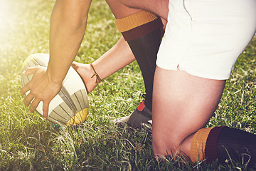 Image showing Rugby, hands closeup and man with a ball outdoor on a pitch for action, goal or start. Male athlete person playing in sport competition, game or training for fitness, workout or exercise on grass