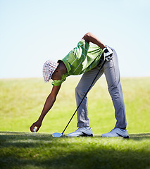 Image showing Sports, golfer and black man with golf ball on lawn for game, match and competition on golfing course. Recreation, hobby and male athlete with club driver on grass for training, fitness and practice