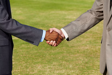 Image showing Closeup, shaking hands and business men on grass for b2b agreement, welcome and teamwork. Businessman, hand shake and collaboration for goal, deal or together for meeting, partnership or thank you