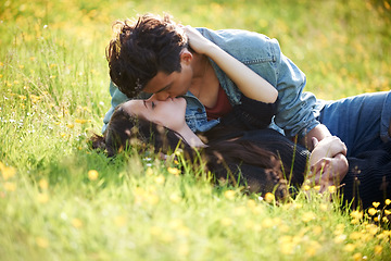 Image showing Love, kiss and peace with couple in grass of field for summer, date and valentines day bonding. Affectionate, romance and nature with man and woman lying in garden meadow for spring, relax and happy