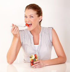 Image showing Woman, eating portrait and fruit salad in a studio with happiness from healthy breakfast and food. Smile, young female person and diet nutrition of a model with organic fruits for wellness and health