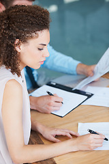 Image showing Business woman, writing and documents in meeting for finance, accounting or planning budget on office desk. Female accountant working on financial report, paperwork or accounts with pen at workplace