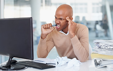 Image showing Stress, computer and burnout with a business man biting his pen at a desk in the office working on a problem. Audit, tax and anger with a frustrated young male employee suffering from anxiety at work