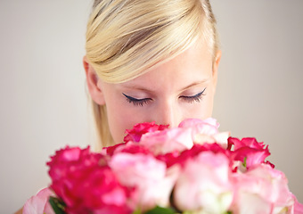 Image showing Smelling, romance and woman with flowers as a gift isolated on a grey studio background. Surprise, romantic and girl with a bouquet of roses for valentines day with a natural, floral present