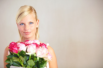 Image showing Portrait, roses and woman in studio for valentines day, gift or thank you gesture on wall background. Face, rose and girl with flowers, plants and relax with floral arrangement and mockup space