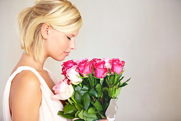 Image showing Bouquet, woman and roses in studio for valentines day, gift or thank you gesture on grey background. Fresh, rose and girl with flowers, happy and relax with floral arrangement and copy space