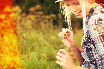 Image showing Lens flare, meadow and woman picking flower in field for freedom, wellness and fresh air outdoors. Nature, summer and hipster female person in countryside for relaxing with plants and sustainability