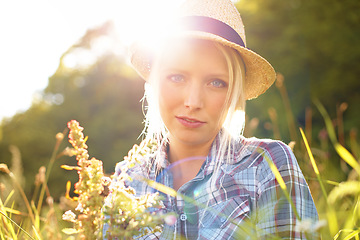 Image showing Lens flare, countryside and portrait of woman with sun in field for freedom, wellness and relax. Nature, hipster and face of female person in flower meadow for sustainability and ecology in summer