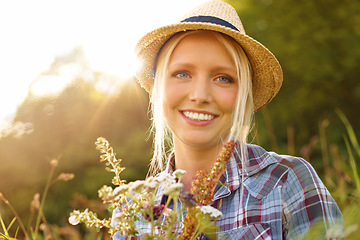 Image showing Countryside, flowers and portrait of woman in field for sustainability, wellness and fresh air outdoors. Nature, summer and face of hipster person in meadow to relax, calm and peace with lens flare