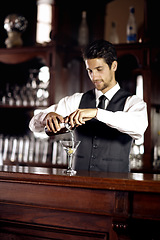 Image showing Bartender man, glass and mixing cocktail at bar for service, drink or hospitality at party, club or event. Male server, barman or waiter with alcohol, spirit or mixer for presentation at restaurant