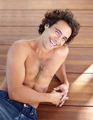 Image showing Shirtless man, portrait and happpy guy in jeans laying down on wood floor with happy and sexy smile. Attractive, healthy and topless male laughing with relaxing, rest and bare chest in sunshine