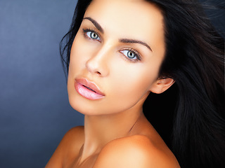 Image showing Beauty, skincare and healthy clean skin of a beautiful young woman with gorgeous blue eyes. Face portrait of a confident, aesthetic and sensual woman posing against a blue studio background
