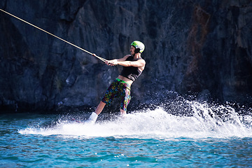 Image showing Splash, surf and wakeboarding with man in lake for extreme sports, summer break and travel vacation. Wave, adrenaline junkie and fitness with guy skiing on river for health, adventure and speed