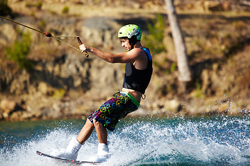 Image showing Water sports, wakeboard and surf with man in lake for training, summer break and travel vacation. Wave, adrenaline junkie and fitness with guy skiing on river for health, adventure and speed