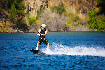 Image showing Wave, sports and wakeboarding with man in lake for action, summer break and travel vacation. Water splash, adrenaline junkie and fitness with guy surfing on river for health, adventure and speed