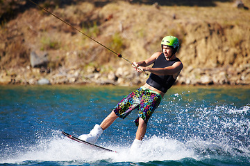 Image showing Splash, surf and wakeboarding with man in lake for extreme sports, summer break and travel vacation. Wave, adrenaline junkie and fitness with guy skiing on river for health, adventure and speed