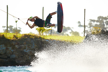 Image showing Training, wakeboard and extreme sports with man in lake for action, summer break and travel vacation. Wave, adrenaline junkie and fitness with guy surfing on river for health, adventure and speed