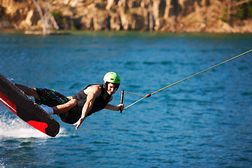 Image showing Surfing, wakeboard and extreme sports with man in lake for action, summer break and travel vacation. Wave, adrenaline junkie and fitness with guy skiing on river for health, adventure and speed