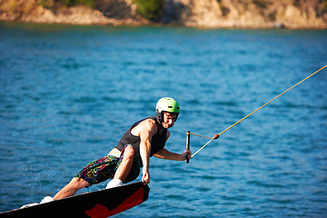 Image showing Wakeboarding, fitness and water sports with man in lake for action, summer break and travel vacation. Wave, adrenaline junkie and training with guy surfing on river for health, adventure and speed