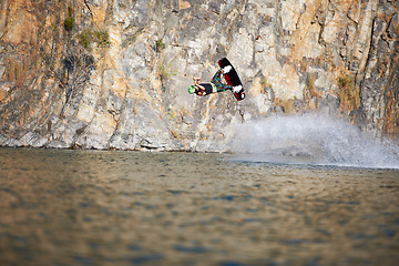 Image showing Jump, wakeboard and extreme sports with man in lake for action, summer break and travel vacation. Wave, adrenaline junkie and fitness with guy surfing on river for health, adventure and speed