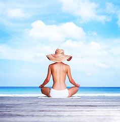 Image showing Travel, meditation and topless with woman at beach for sunbathing, summer and freedom in Bali. Relax, yoga and tropical with girl meditating in bikini on vacation for mockup, peace and beauty