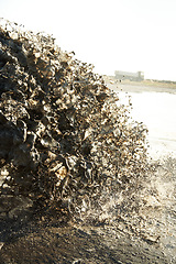 Image showing Pollution, pipeline and dirt in water to ocean from industrial waste for construction, sewer and danger. Environment, texture and industry with wave from sewage on shoreline for stream, foam and mud