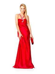 Image showing Young and elegant woman in a red dress or fancy gown while feeling confident and beautiful against a copy space background. Lady wearing designer clothes and accessories for prom, bridesmaid or event