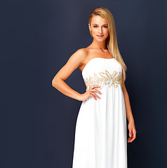 Image showing Beautiful woman in a white gala dress and looking gorgeous for prom, orcars or red carpet event. Portrait a fashion and beauty model looking posh in a designer gown with copy space background