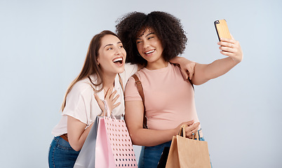 Image showing Friends, women with shopping bag and happy in selfie, retail customer and fashion isolated on studio background. Excited female people smile in picture, sale and discount with promotion at boutique