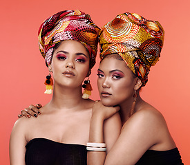 Image showing African fashion, beauty and portrait of women on orange background with cosmetics, makeup and accessories. Glamour, friends and female people with exotic jewelry, traditional style and head scarf
