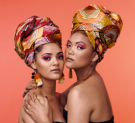 Image showing Fashion, beauty and portrait of African women on orange background with cosmetics, makeup and accessories. Glamour, luxury and face of female people hug in exotic jewelry, traditional style and scarf