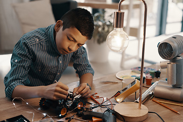 Image showing Education, car robot and child in home with homework, homeschool and science, learning and tech project. Robotics, building and boy kid with electrical knowledge, engineering and studying in house.