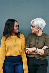 Image showing Black woman, senior businesswoman and talking on break or conversation with employee, friend or mentor. Women, mature colleague or happy together and discussion outside work on blue background
