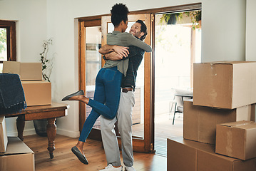 Image showing Happy couple, hug and real estate moving in new home for relocation, renovation or investment together. Interracial man hugging woman and homeowners with boxes in house for move, mortgage or property