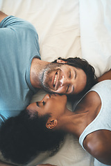 Image showing Happy interracial couple, kiss and relax on bed above for morning bonding, intimate relationship or love at home. Top view of woman kissing man lying in bedroom for loving romance, care or affection