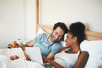 Image showing Happy couple, tablet and laughing on bed for joke, funny entertainment or online streaming at home. Interracial man and woman person on technology in relax for morning or social media in the bedroom