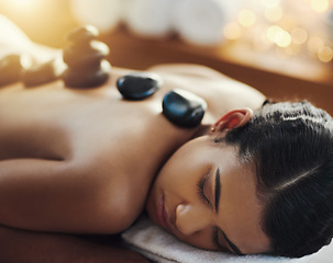 Image showing Woman, relax and sleeping in rock massage at spa for skincare, beauty or body treatment at resort. Calm female asleep in relaxation with hot rocks or pile on back in therapy, zen or wellness at salon