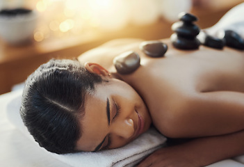 Image showing Happy woman, relax and sleeping in rock massage at spa for skincare, beauty or body treatment. Calm female asleep in relaxation with hot rocks or pile on back in therapy, zen or wellness at salon