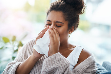 Image showing Sick, virus and a woman blowing nose on the sofa with covid, hay fever or allergies in a house. Flu, young lady and an allergy, sinus problem or sneezing into a tissue on the living room couch