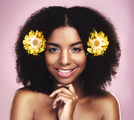 Image showing Portrait, happy woman and hair care with yellow flowers in studio, pink background or natural beauty. Face of african model, skincare and daisy plants in afro for sustainable cosmetics, smile or glow