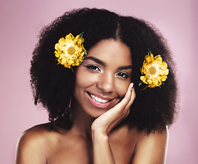 Image showing Portrait, face and happy woman with flowers in afro, studio and pink background for beauty, floral aesthetic and shine. African model, natural skincare and daisy plants in hair for organic cosmetics