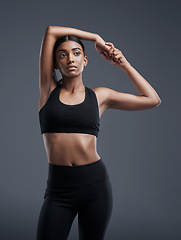 Image showing Idea, mockup and stretching with an athlete woman in studio on a gray background for fitness or health. Exercise, thinking and warm up with an attractive young female model training her body