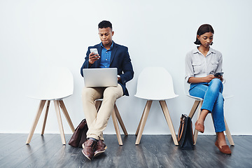 Image showing Phone, laptop and people in interview waiting room and search the internet, web or website sitting on chairs. Internship, work and young employees texting or typing online ready for a new job