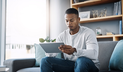 Image showing Relax, tablet and man on sofa, internet scroll and reading social media post, email or streaming video on subscription. Mobile app, info and online connection, person surfing movie website on couch.