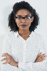 Image showing Business portrait, serious and black woman with arms crossed in studio isolated on a white background. Glasses, confidence and face of African female professional, entrepreneur or person from Nigeria