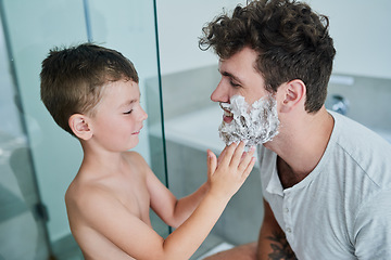 Image showing Father, kid and learning how to shave in bathroom, having fun or bonding together. Smile, child and dad teaching with shaving cream on face, playing and cleaning, hygiene and enjoying quality time.