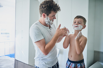 Image showing Father, kid and learning to shave in bathroom, education and bonding together. Care, dad and teaching child with shaving cream on face, playing or cleaning, hygiene or enjoying hair removal in home.