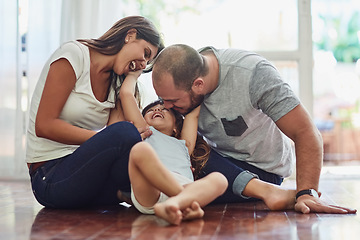 Image showing Family, parents with their daughter playing and happy in living room of their home. Love or care, support and cheerful or happy people spend quality or bonding time together on floor at their house.