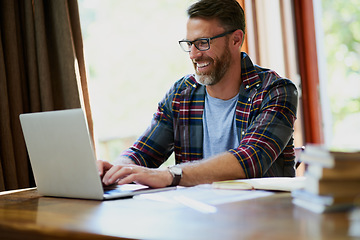 Image showing Man, laptop and working from home while typing for search, email or streaming online for research. Freelancer and entrepreneur with internet connection and books for remote work, planning or learning