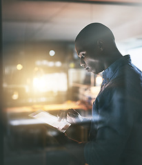 Image showing Black business man, night and tablet with analysis, planning or focus for deadline, research or project. African businessman, digital touchscreen or web design for ux, website or reading in workplace